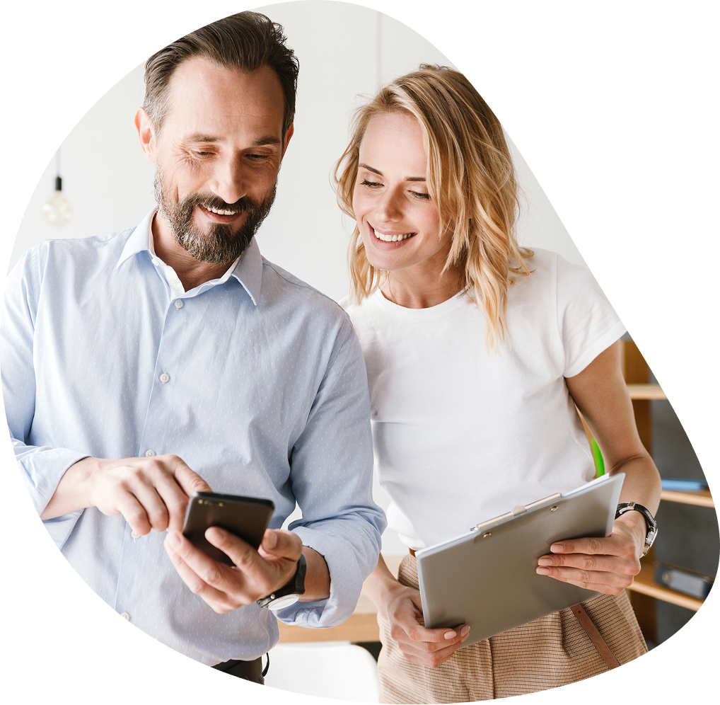 Smiling colleagues checking phone with clipboard | Hemmat Law Group
