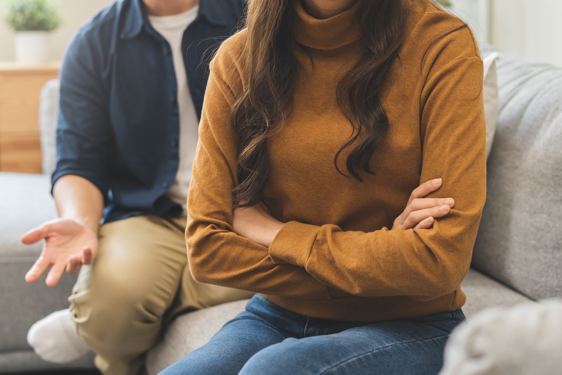 Couple having tense discussion while seated on a sofa | Hemmat Law Group