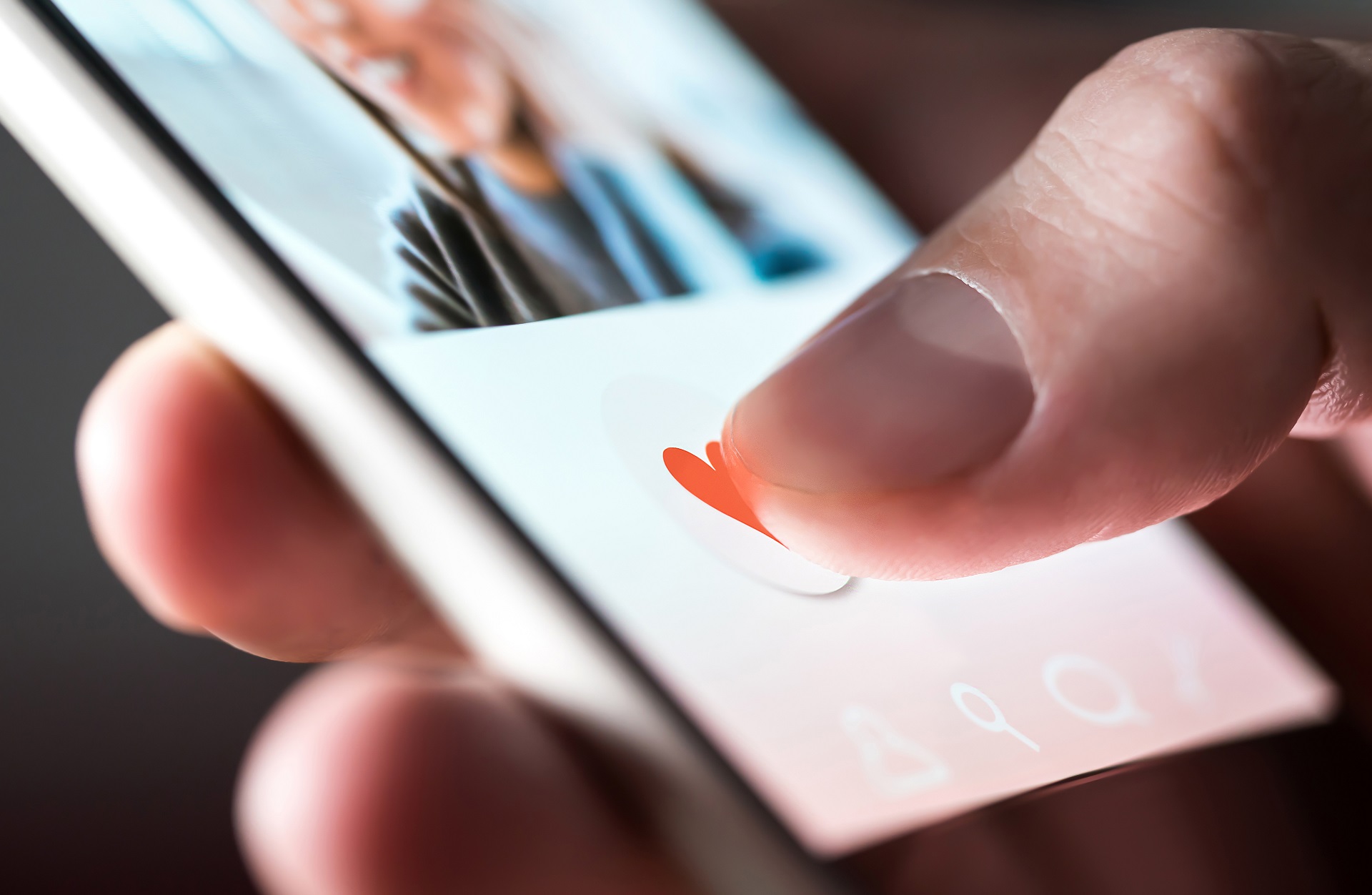 Person tapping a heart icon on a mobile dating app | Hemmat Law Group