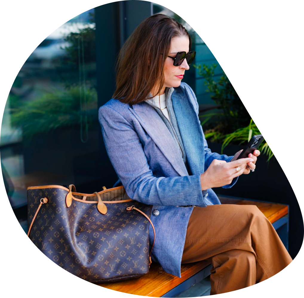 Stylish woman checking phone on a bench | Hemmat Law Group