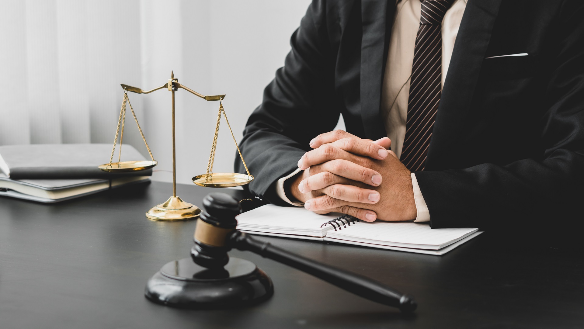 Attorney seated with gavel and scales during legal consultation | Hemmat Law Group