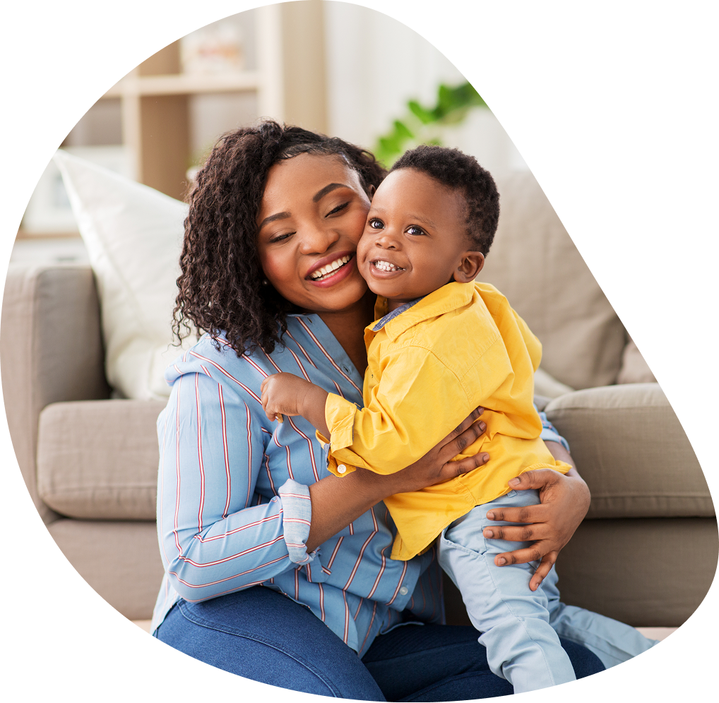 Smiling mother hugging young son on couch | Hemmat Law Group