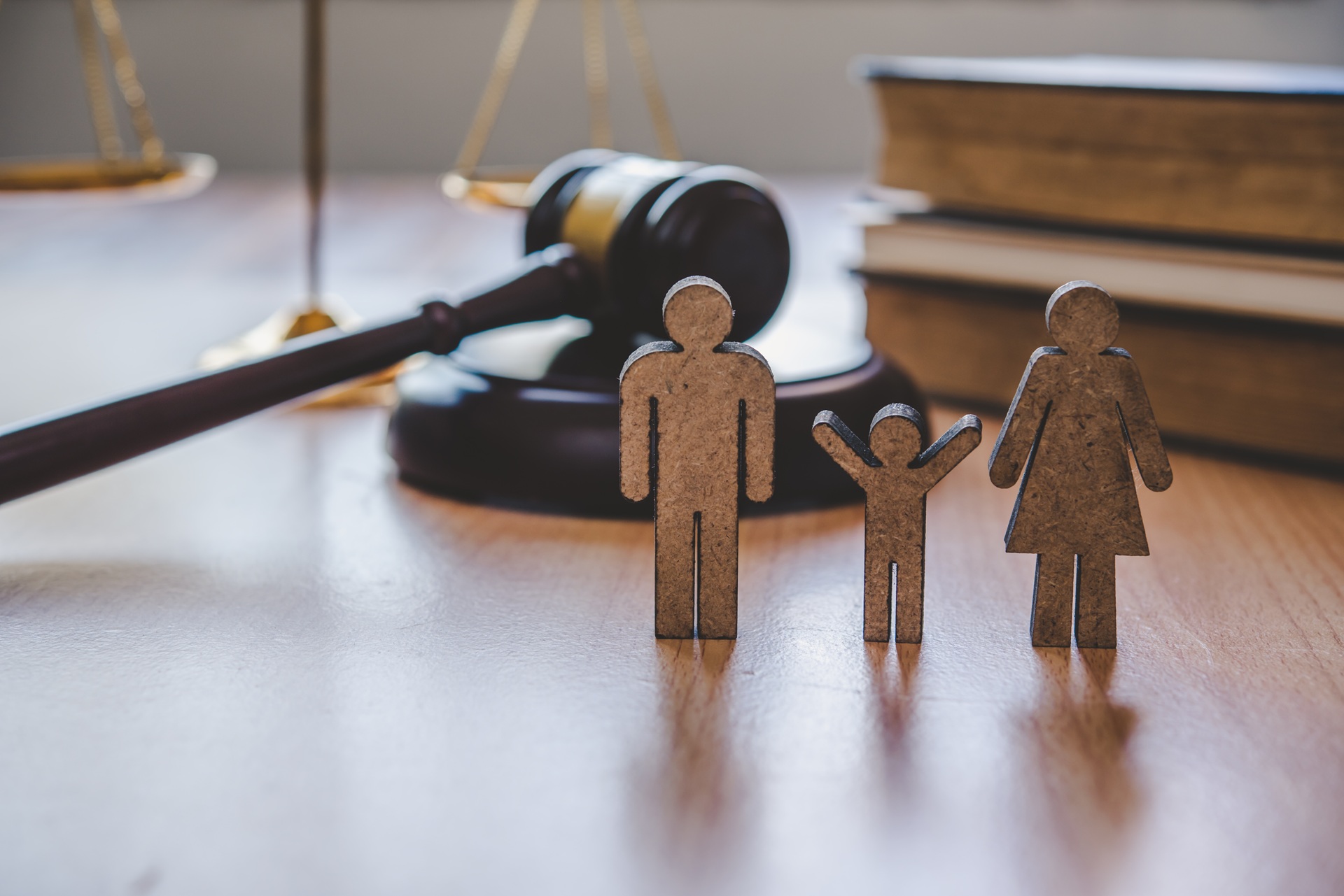 Wooden family figures standing before gavel | Hemmat Law Group