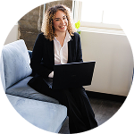 Professional woman working on a laptop from a sofa | Hemmat Law Group