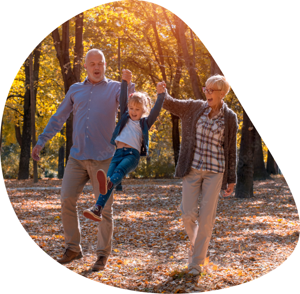 Grandparents swinging girl through autumn leaves | Hemmat Law Group