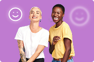 Two women laughing together against a purple background | Hemmat Law Group