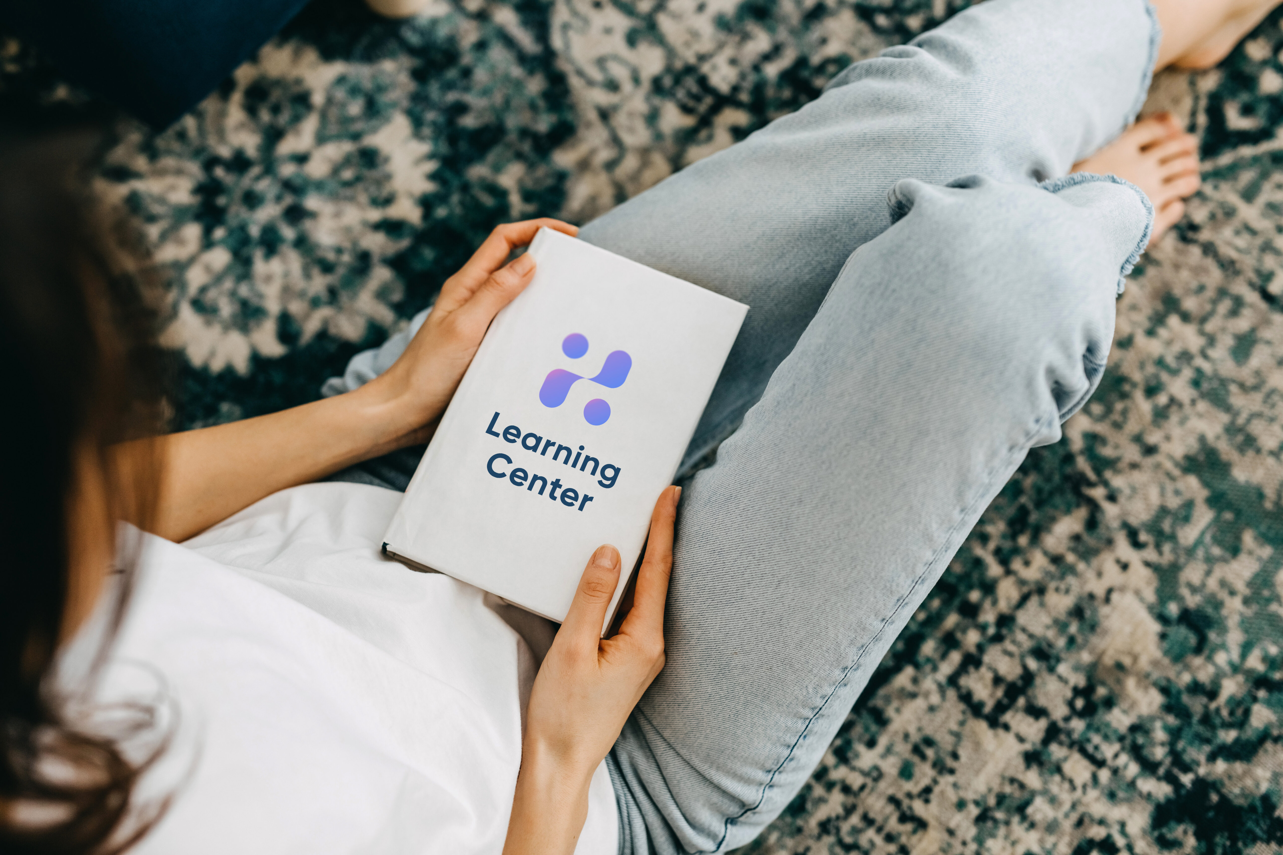 Woman holding 'Learning Center' book on lap | Hemmat Law Group