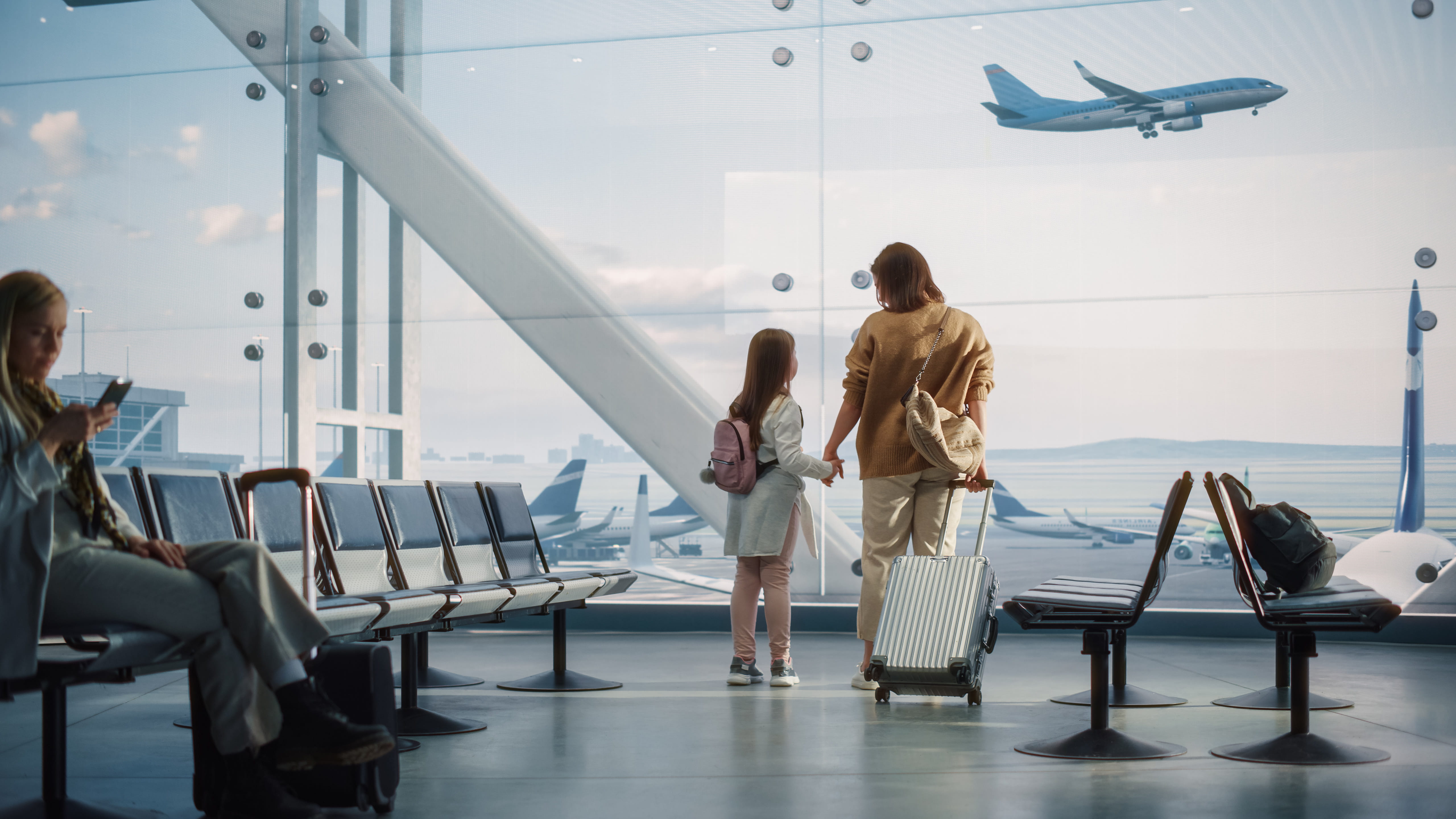 Mother and daughter waiting together inside an airport | Hemmat Law Group
