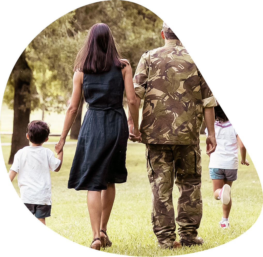 Military family walking together across grass | Hemmat Law Group