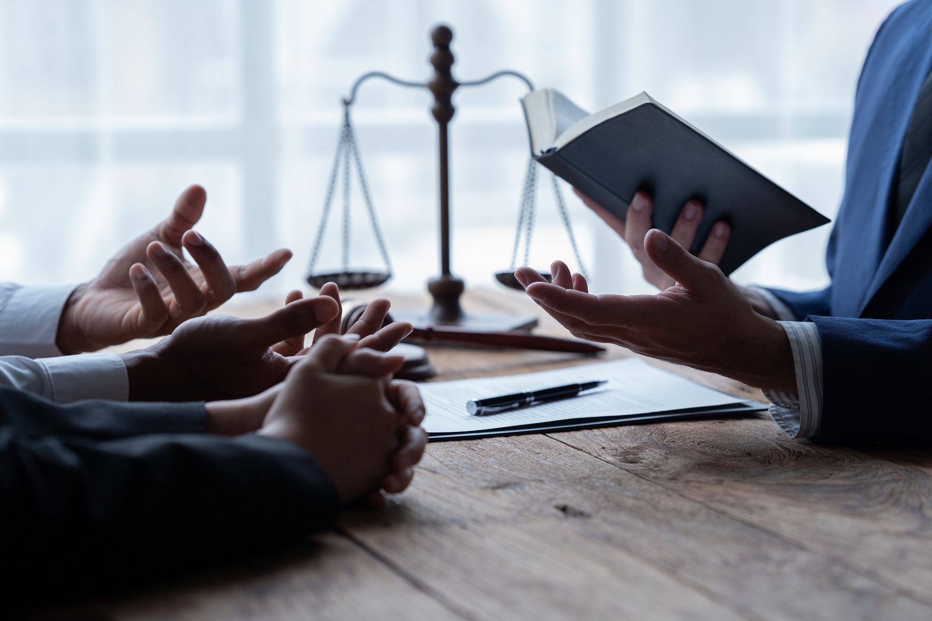 Lawyer discussing case near scales of justice | Hemmat Law Group