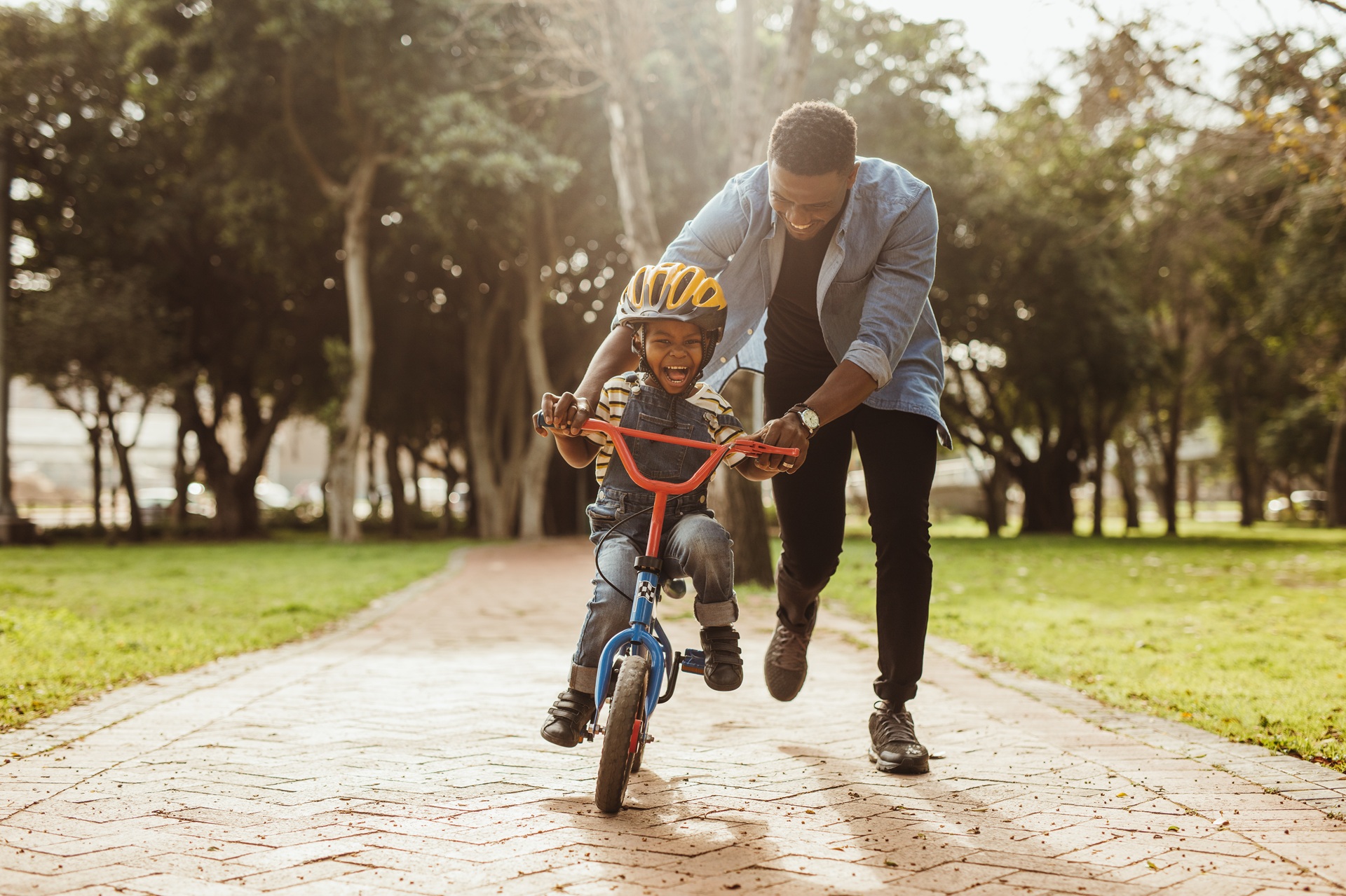 Father teaching son to ride a bicycle | Hemmat Law Group