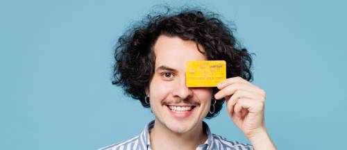 Curly-haired man smiling with credit card | Hemmat Law Group