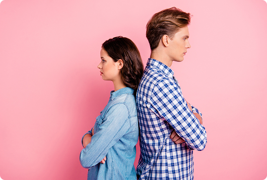 Young couple standing back to back against a pink background | Hemmat Law Group