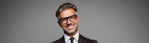 Man in suit and glasses smiling | Hemmat Law Group