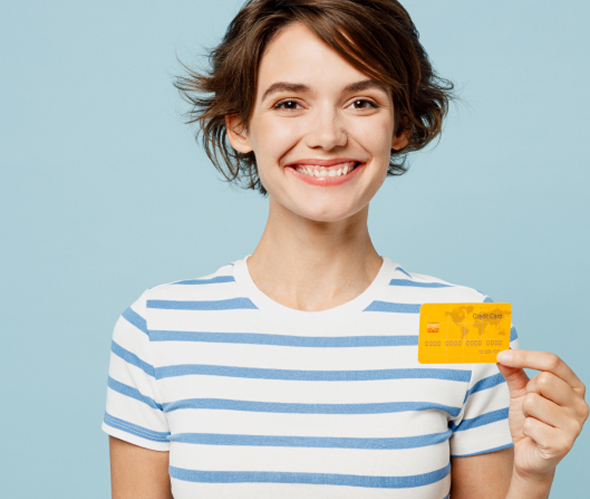 Smiling woman holding a yellow credit card against blue backdrop | Hemmat Law Group