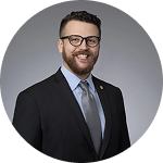 Male attorney in suit and glasses shown in circular portrait | Hemmat Law Group