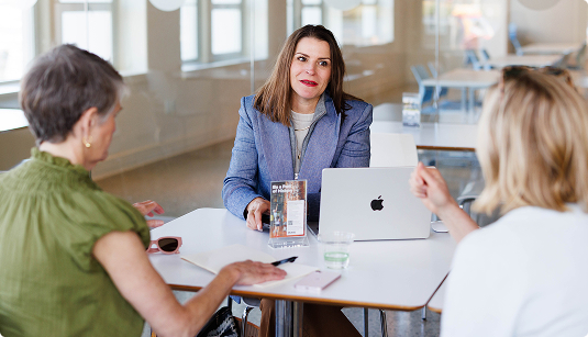 Attorney meeting with two women around an office table | Hemmat Law Group